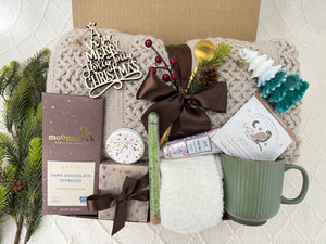 Hallelujah Gift Box featuring a throw blanket, white fluffy socks, wooden Christmas ornament, handmade soap, bath salt, shower steamer, hand cream, coffee mug, golden coffee spoon, herbal tea, Christmas tree candle, and gourmet chocolate.